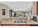 Kitchen peninsula featuring granite countertops and stainless sink overlooking the living room at 10213 Saint Francis Ter, Palmetto, FL 34221