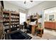 Office space with ceiling fan, desk, shelving, and view to bathroom at 10213 Saint Francis Ter, Palmetto, FL 34221