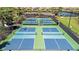 Aerial view of blue and green pickleball courts in a well-maintained residential community at 10213 Saint Francis Ter, Palmetto, FL 34221