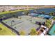 Overhead view featuring multiple tennis courts with a lake in the background, ideal for tennis enthusiasts at 10213 Saint Francis Ter, Palmetto, FL 34221