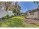 Well-maintained backyard featuring lush green grass, a white picket fence, and a landscaped garden area at 10810 Moss Island Dr, Riverview, FL 33569