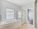 Bathroom featuring a large soaking tub and a glass shower with tiled floor and window at 10810 Moss Island Dr, Riverview, FL 33569