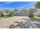 Attractive home featuring a wide driveway, well-manicured landscaping, and a three-car garage at 10810 Moss Island Dr, Riverview, FL 33569