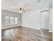 Spacious living room featuring beautiful wood floors, neutral walls, and an arched doorway at 10810 Moss Island Dr, Riverview, FL 33569