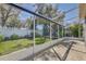 Enclosed porch with screen walls, tiled floor, and views of the landscaped backyard and privacy fence at 10810 Moss Island Dr, Riverview, FL 33569