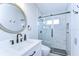 Modern bathroom featuring glass enclosed shower and updated vanity with a round mirror at 1116 Jacob Way, Odessa, FL 33556