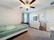 Bedroom featuring a ceiling fan, natural light, and a bed with a white frame and green comforter at 11817 Blackeyed Susan Dr, Riverview, FL 33579