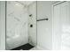 This glass shower has white marble-look tile and black fixtures, creating a modern look at 122 Jennifer Dr, Rotonda West, FL 33947
