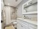 Bathroom featuring modern fixtures, neutral tile, decorative shower curtain, and vanity mirror at 14005 Trouville Dr, Tampa, FL 33624