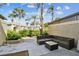 A peaceful patio with a contemporary seating arrangement, palm trees, and blue skies offers an outdoor living space at 14005 Trouville Dr, Tampa, FL 33624