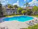 A beautiful community swimming pool surrounded by lush landscaping and plenty of lounge chairs for relaxation and sunbathing at 14005 Trouville Dr, Tampa, FL 33624