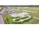 Aerial view of a modern skate park and running trail surrounded by green spaces, perfect for outdoor activities and recreation at 14005 Trouville Dr, Tampa, FL 33624