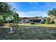 Spacious backyard featuring lush greenery, a well-manicured lawn, and a charming patio area for relaxing and entertaining at 1730 W Del Webb Blvd, Sun City Center, FL 33573