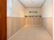This is a picture of an empty basement with wood paneled walls, tile floors, and decorative shelving at 1730 W Del Webb Blvd, Sun City Center, FL 33573