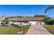 Charming single-story home with brick accents, lush lawn, and a brick-paved driveway leading to an attached garage at 1730 W Del Webb Blvd, Sun City Center, FL 33573