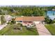 Inviting home with brick facade, well-manicured lawn, and beautiful landscaping near a tranquil lake at 1730 W Del Webb Blvd, Sun City Center, FL 33573