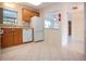 Bright kitchen features wood cabinets, white appliances, tile flooring, and a convenient pass-through for seamless entertaining at 1730 W Del Webb Blvd, Sun City Center, FL 33573