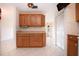 A functional kitchen showcasing wood cabinets, offering ample storage, complemented by tile floors and a pass-through to other rooms at 1730 W Del Webb Blvd, Sun City Center, FL 33573