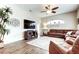 Comfortable living room featuring hardwood floors, a large sofa, and a ceiling fan for added comfort at 17320 Hubers Ct, Odessa, FL 33556