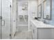 Modern bathroom with double sinks, sleek countertops, and a glass-enclosed shower, leading to a walk-in closet at 17420 Moonflower Dr # 103, Venice, FL 34293