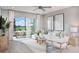 Bright living room with a large sliding door to the patio, plush white sofa, and modern decor at 17420 Moonflower Dr # 103, Venice, FL 34293