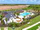 Aerial view of a resort-style pool, cabanas, clubhouse, and landscaped grounds at 17420 Moonflower Dr # 103, Venice, FL 34293