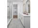 Elegant bathroom with a glass-enclosed shower, double vanity, gold accents, and walk-in closet at 17420 Moonflower Dr # 202, Venice, FL 34293