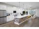 Bright, open kitchen featuring white cabinets, a floral accent island, stainless steel appliances and pendant lighting at 17420 Moonflower Dr # 202, Venice, FL 34293