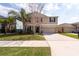 Beautiful two-story home with a well-kept lawn, mature palm trees, and a wide driveway at 1757 Broad Winged Hawk Dr, Ruskin, FL 33570