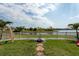 The backyard provides a serene lake view from the grass, beach rocks, and a small firepit at 1757 Broad Winged Hawk Dr, Ruskin, FL 33570