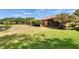 Wide shot of a sunny backyard featuring a screened lanai and mature trees along a home's exterior at 178 Shell Falls Dr, Apollo Beach, FL 33572