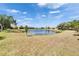 Wide shot of community lake surrounded by grass and a bright blue sky at 178 Shell Falls Dr, Apollo Beach, FL 33572