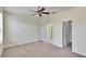 Bright bedroom with neutral carpet, ceiling fan, and ensuite bathroom and walk-in closet at 178 Shell Falls Dr, Apollo Beach, FL 33572