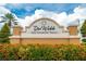 Del Webb Southshore Falls community entrance sign with manicured landscaping and vibrant flowers, setting a welcoming tone at 178 Shell Falls Dr, Apollo Beach, FL 33572