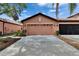 Exterior garage view with well-maintained landscaping and mature palms in a bright and sunny setting at 178 Shell Falls Dr, Apollo Beach, FL 33572