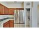Kitchen with stainless steel refrigerator, rich wood cabinets, and a pantry at 178 Shell Falls Dr, Apollo Beach, FL 33572