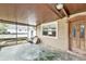 View of screened-in back porch with weathered floor and wooden door at 1819 Shore Acres Ne Blvd, St Petersburg, FL 33703