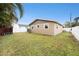 Exterior of home with a fenced backyard, lush lawn and tropical landscaping at 1819 Shore Acres Ne Blvd, St Petersburg, FL 33703