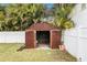 Fenced backyard featuring a shed with double doors on a grassy lawn at 1819 Shore Acres Ne Blvd, St Petersburg, FL 33703