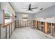 Partially renovated bedroom has concrete walls and two bright windows with a view; modern ceiling fan at 1819 Shore Acres Ne Blvd, St Petersburg, FL 33703