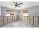Bedroom renovation featuring raw concrete walls, contrasted by updated windows and a modern ceiling fan at 1819 Shore Acres Ne Blvd, St Petersburg, FL 33703