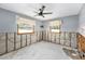 Partially renovated bedroom with raw concrete walls, complemented by two bright windows and a modern ceiling fan at 1819 Shore Acres Ne Blvd, St Petersburg, FL 33703