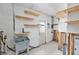 Renovating laundry room with block walls, wood shelves, utility sink, and doorway to adjacent space at 1819 Shore Acres Ne Blvd, St Petersburg, FL 33703