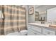 Bathroom featuring a shower with a patterned shower curtain and a vanity with updated fixtures at 19437 Ship Wheel Way, Land O Lakes, FL 34638