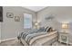 Cozy bedroom with a striped bedspread, side tables with lamps, and neutral decor at 19437 Ship Wheel Way, Land O Lakes, FL 34638