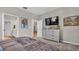 Comfortable bedroom featuring a dresser with TV, neutral walls, and calming decor at 19437 Ship Wheel Way, Land O Lakes, FL 34638