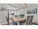 Open-concept dining area featuring a stylish table with seating for six, modern light fixture, and an adjacent kitchen at 19437 Ship Wheel Way, Land O Lakes, FL 34638