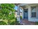 Inviting front entrance showcases a blue door adorned with a wreath, complemented by stylish columns and verdant landscaping at 19437 Ship Wheel Way, Land O Lakes, FL 34638