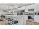 Modern kitchen with stainless steel appliances, white cabinets, a breakfast bar with seating, and a view into the living area at 19437 Ship Wheel Way, Land O Lakes, FL 34638