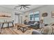 Bright living room with hardwood floors, large windows, and a cozy couch, creating a comfortable and inviting atmosphere at 19437 Ship Wheel Way, Land O Lakes, FL 34638